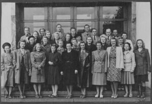 Lohjan Sähkö Oy:n henkilökuntaa ryhmäkuvassa noin 1938-41. Toini Kyttälä eturivissä kuudes vasemmalta yllään leninki, jossa terävänipukkaiset kaulukset vielä paikoillaan.