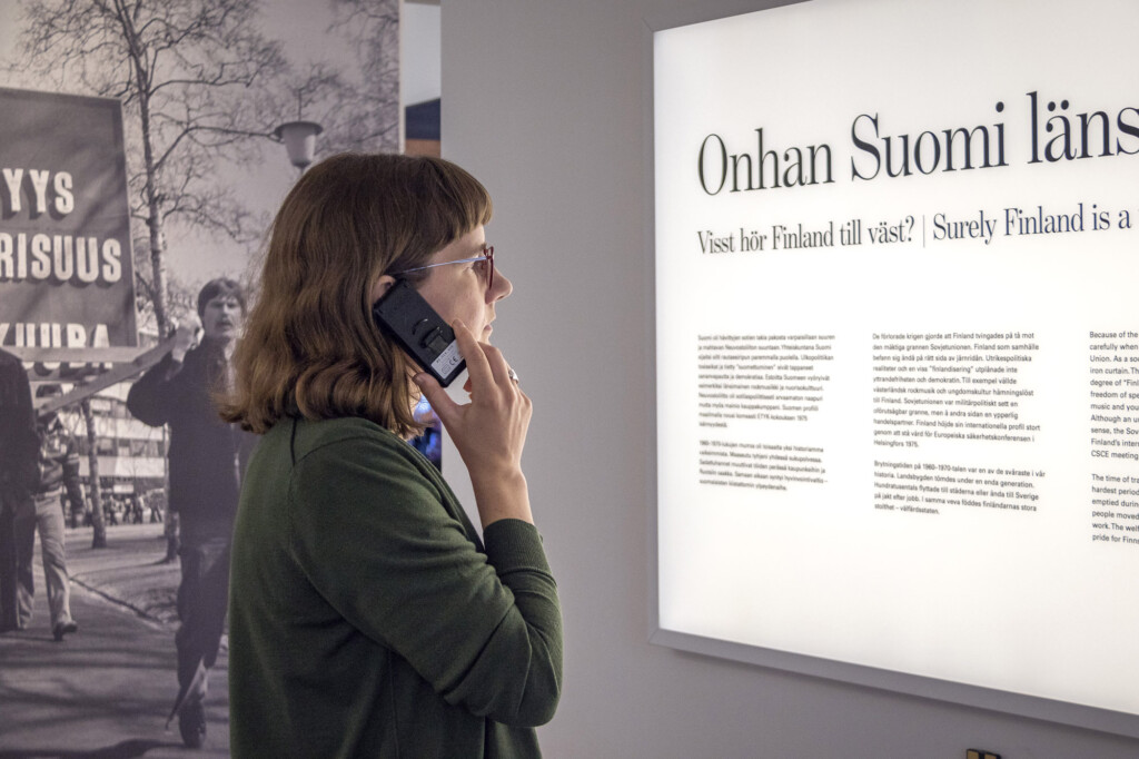 Asiakas kuuntelee museon sisältöjä museossa.