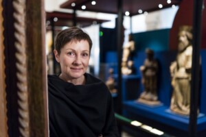 Nainen katsoo näyttelyn seinämän takaa